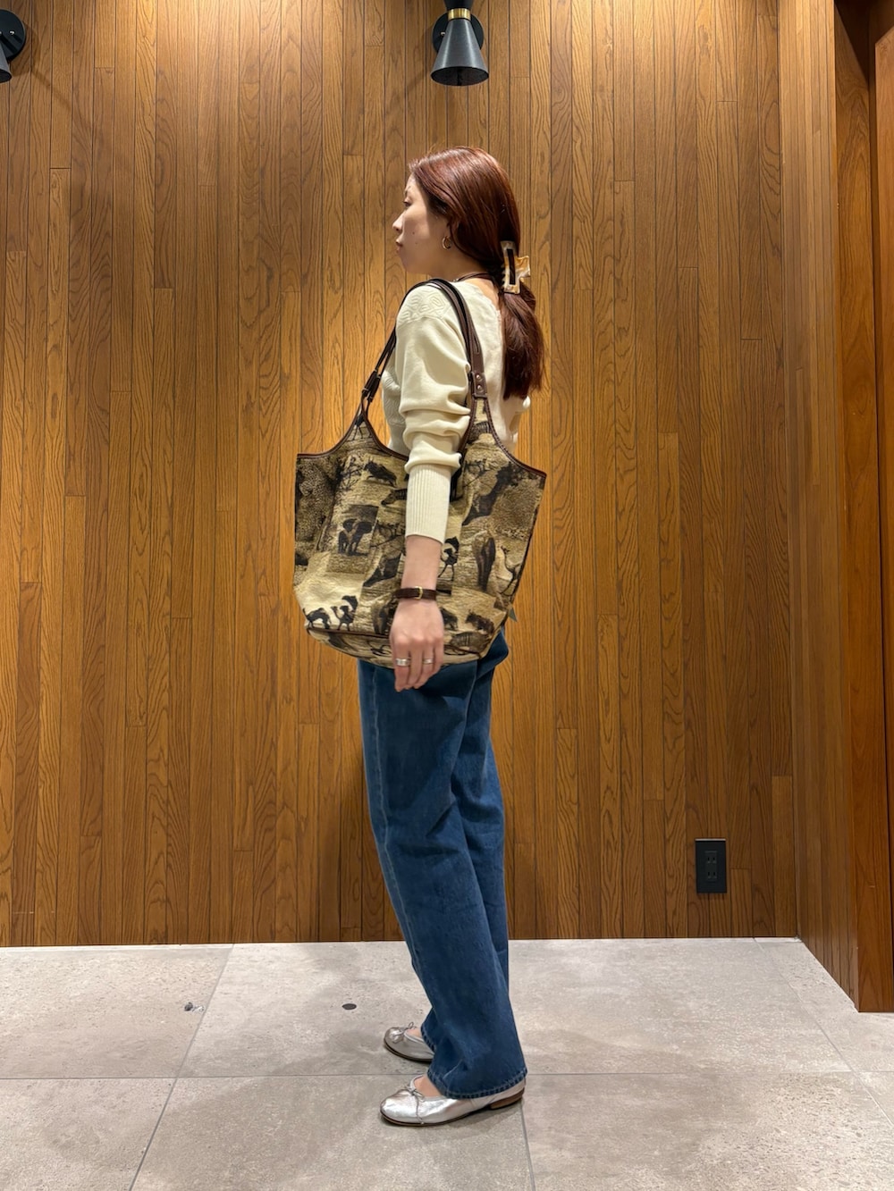 ホワイト系のニット/セーター、ブルー系のデニムパンツを着用したレディースの春コーディネートの2枚目の写真