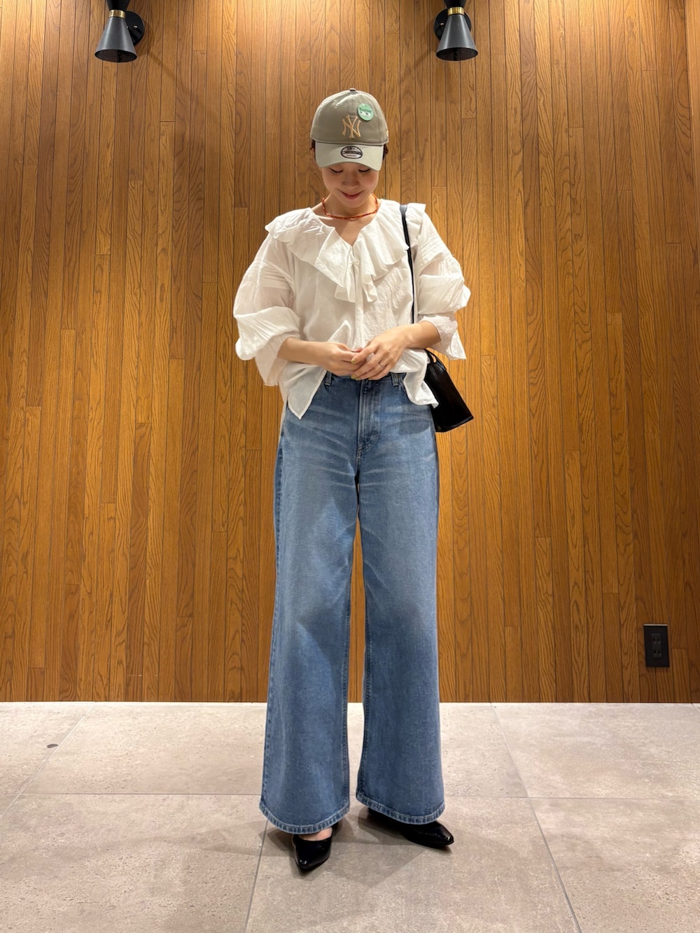 ベージュ系のトレンチコート、ホワイト系のシャツ/ブラウス、ブルー系のデニムパンツを着用したレディースの春コーディネートの7枚目の写真