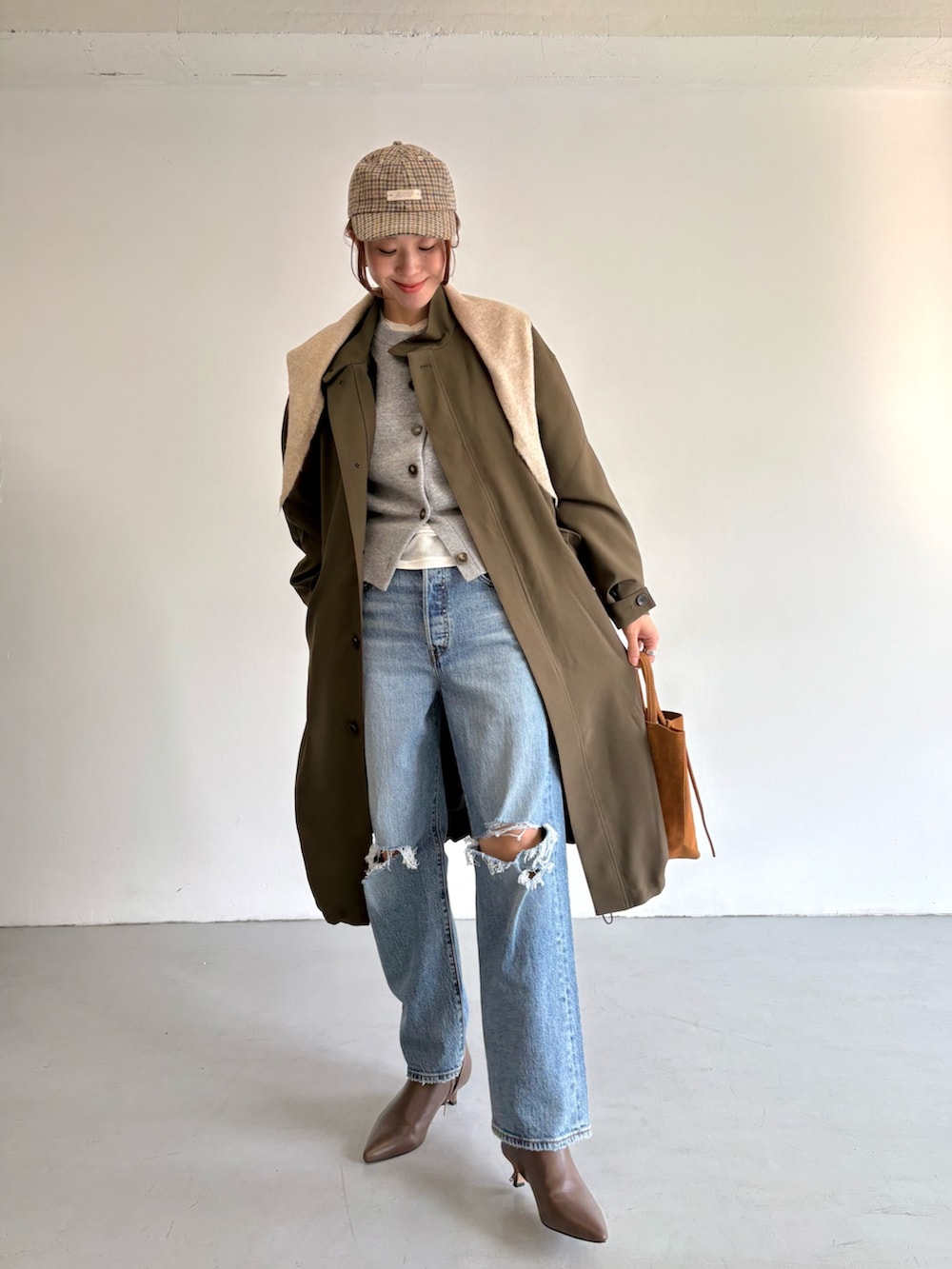 ブルー系のデニムパンツ、ベージュ系のトートバッグ、ホワイト系のTシャツ/カットソーを着用したレディースの冬コーディネートの6枚目の写真