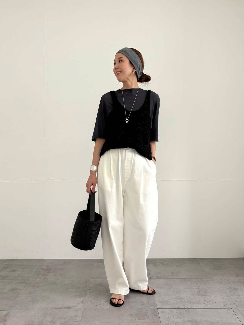 ブラック系のかごバッグ、ホワイト系のその他パンツ、ブラック系のサンダルを着用したレディースの夏コーディネートの4枚目の写真