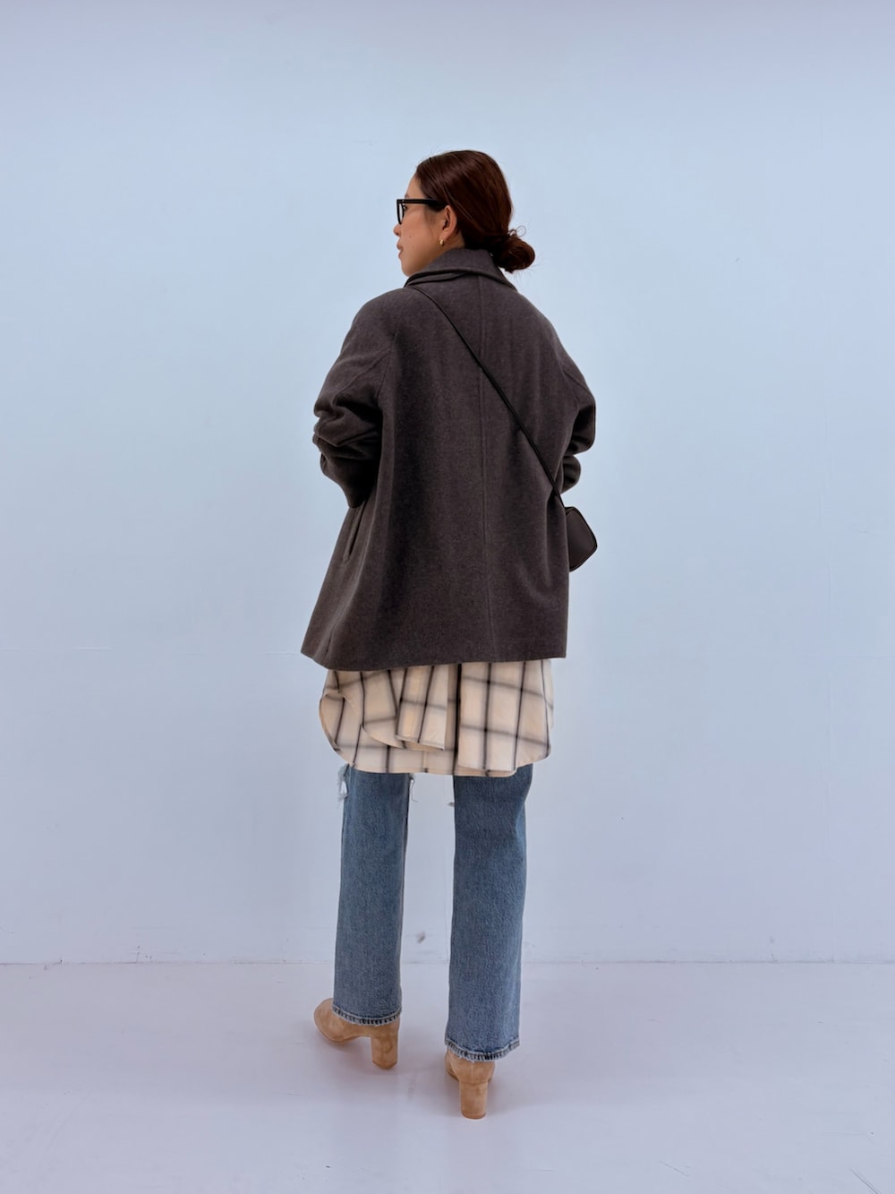 ブルー系のデニムパンツ、グリーン系のカーディガン/ボレロ、ホワイト系のピーコートを着用したレディースの秋コーディネートの3枚目の写真