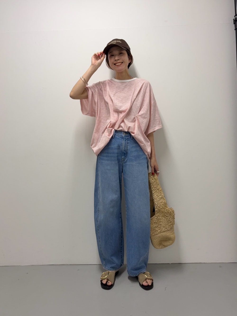 ピンク系のTシャツ/カットソー、ブルー系のデニムパンツ、ベージュ系のサンダルを着用したレディースの夏コーディネートの4枚目の写真