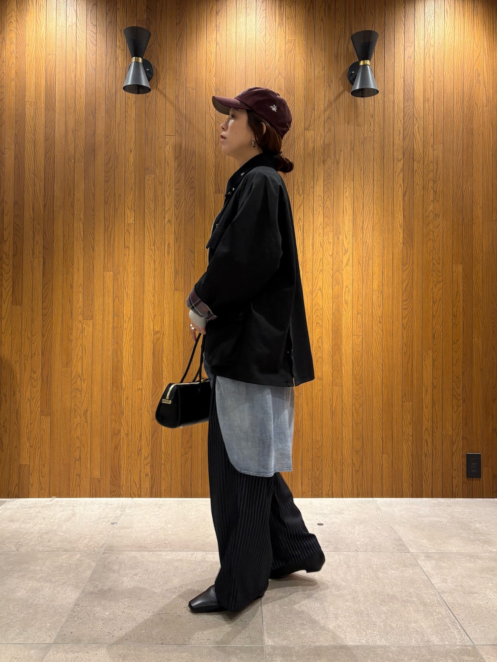 ブラック系のその他アウター、グレー系のその他パンツ、ブラック系のローファーを着用したレディースの秋コーディネートの5枚目の写真