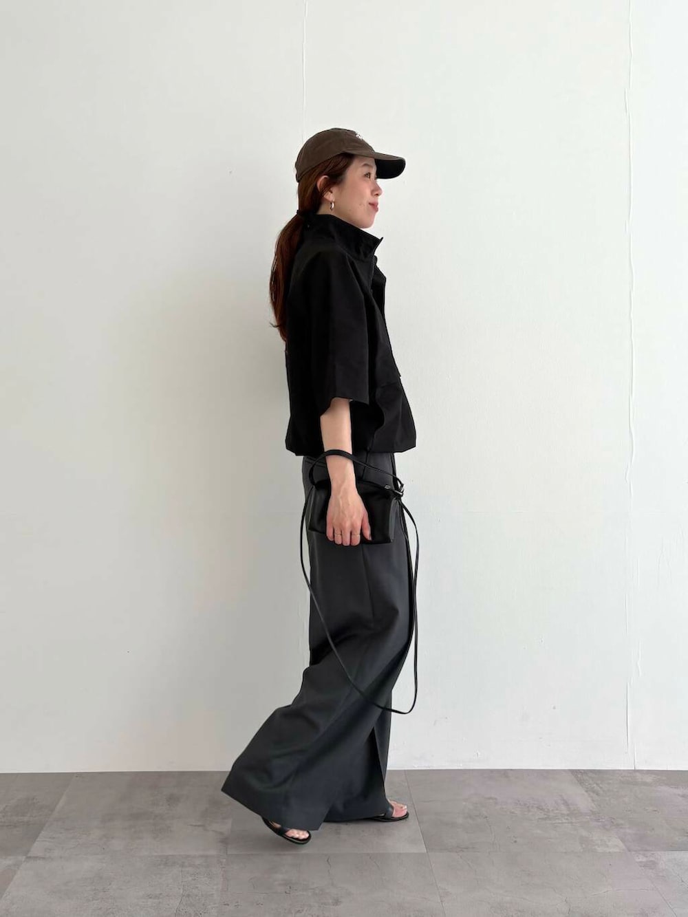 グレー系のその他パンツ、ブラック系のTシャツ/カットソー、ブラック系のショルダーバッグを着用したレディースの夏コーディネートの2枚目の写真