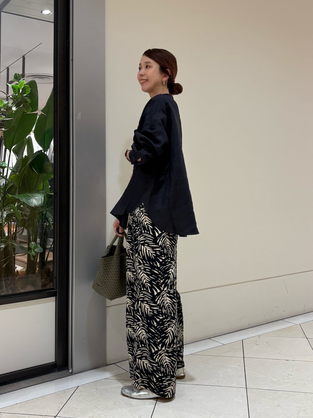 ブルー系のシャツ/ブラウス、ブラック系のその他パンツ、グリーン系のトートバッグを着用したレディースの春コーディネートの3枚目の写真