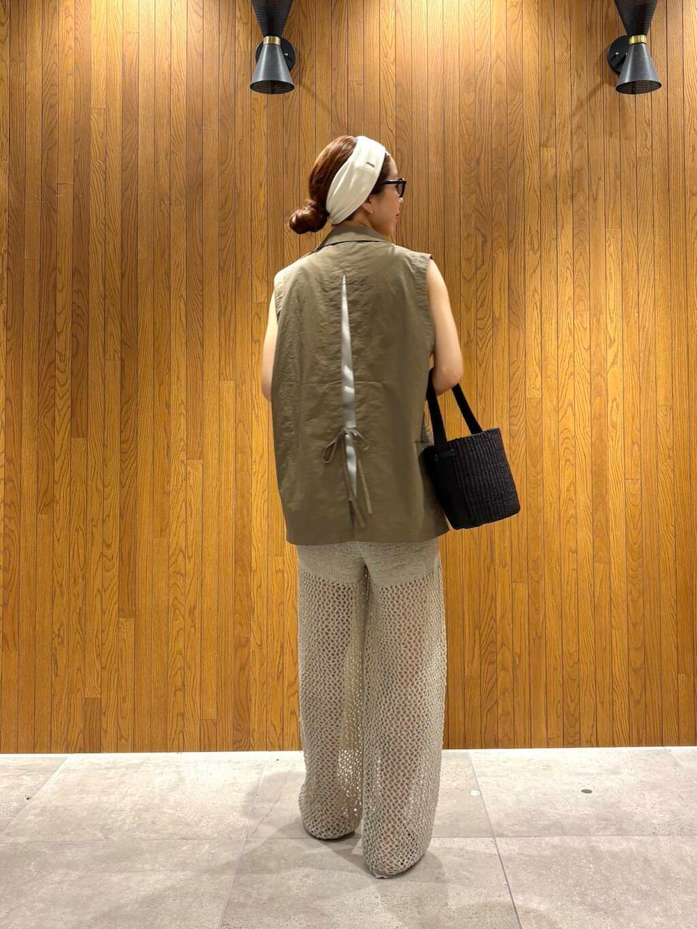 ブラック系のかごバッグ、ゴールド系のサンダル、グレー系のその他パンツを着用したレディースの夏コーディネートの4枚目の写真