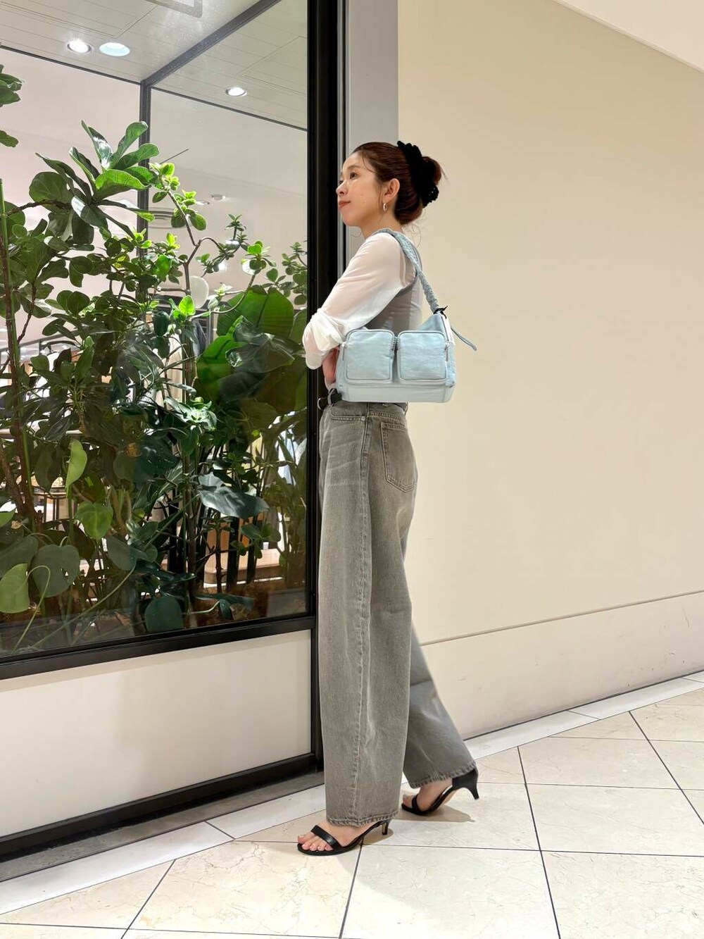 グリーン系のデニムパンツ、グリーン系のショルダーバッグ、グレー系のTシャツ/カットソーを着用したレディースの夏コーディネートの3枚目の写真