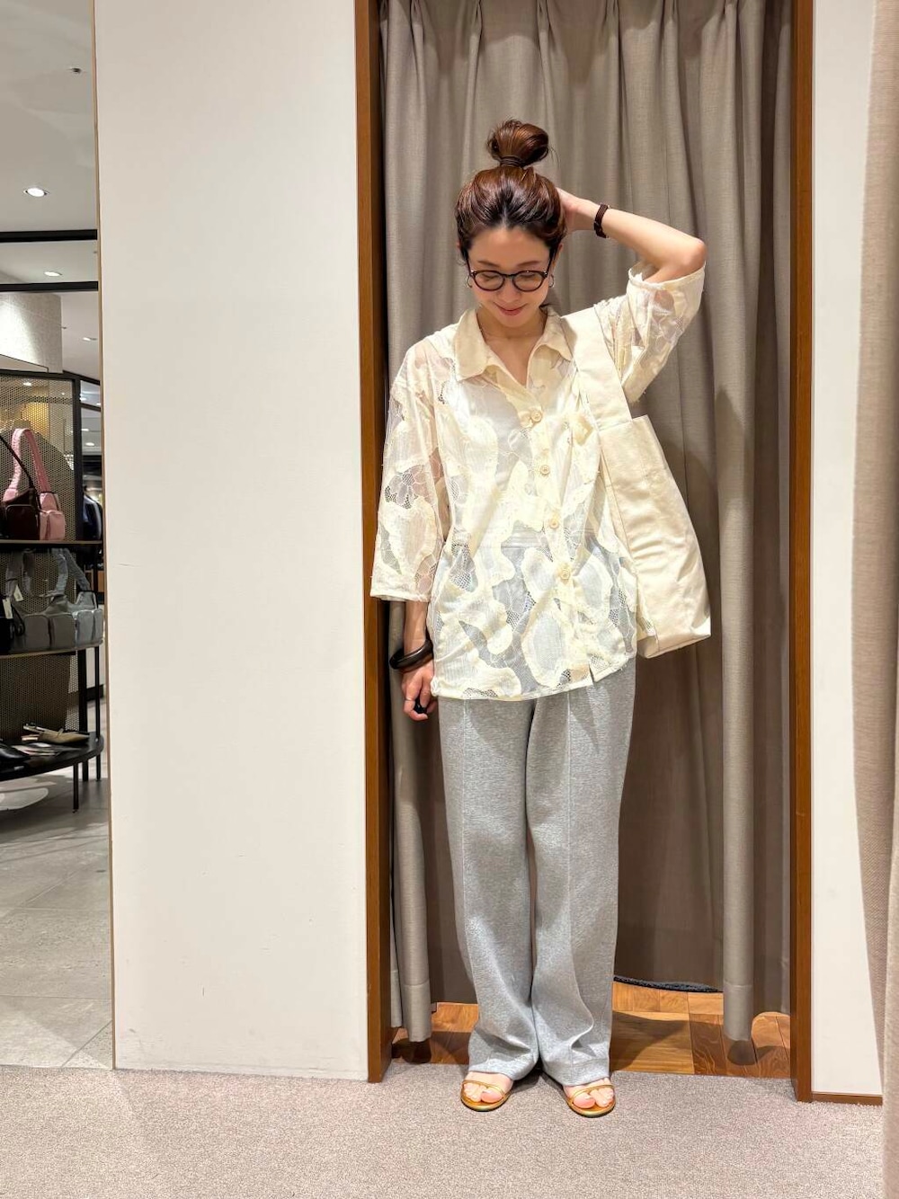 ベージュ系のトートバッグ、グレー系のその他パンツ、ゴールド系のネックレスを着用したレディースの春コーディネートの2枚目の写真