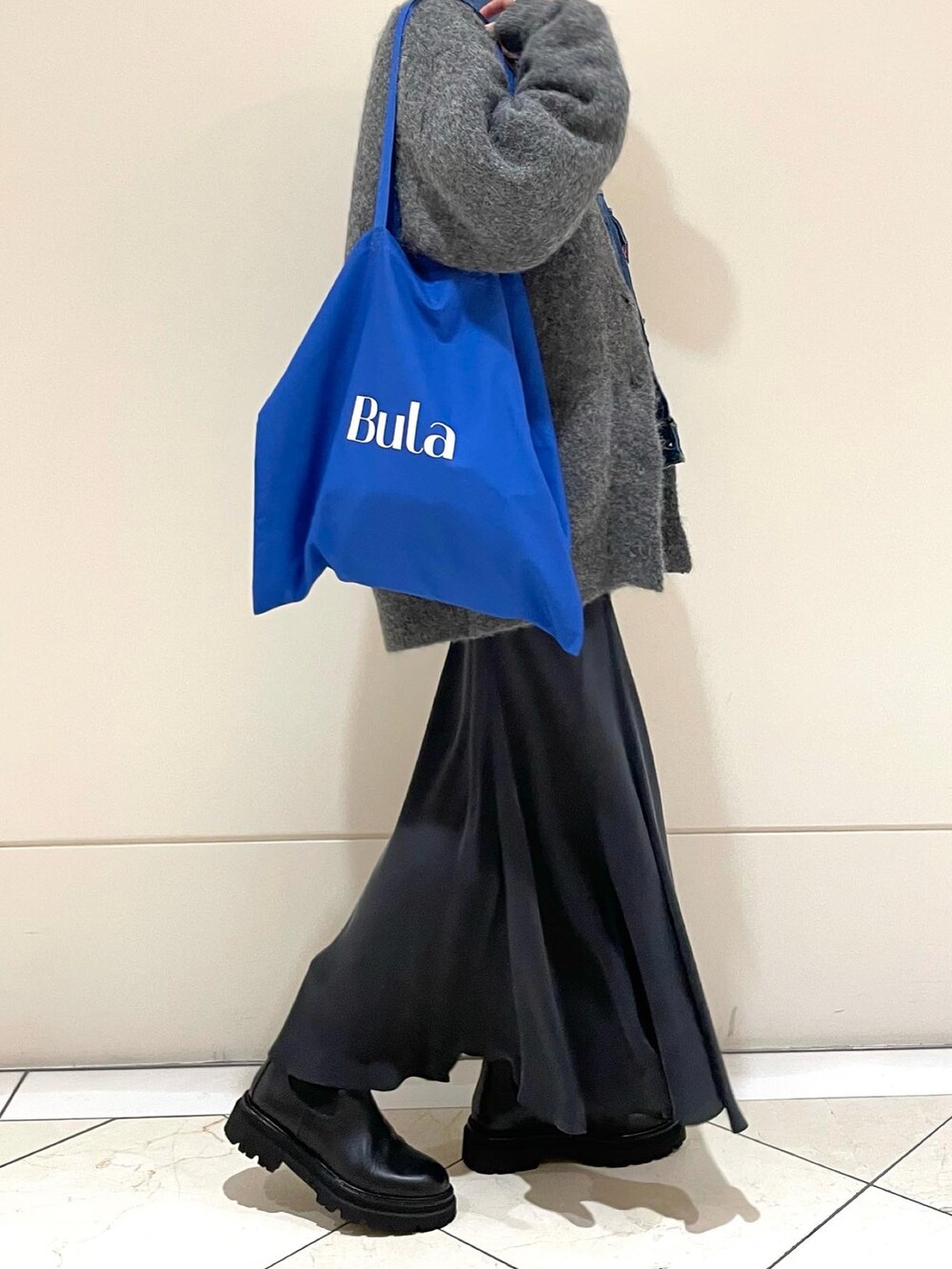 グリーン系のスカート、ブラック系のブーツ、ブルー系のデニムジャケットを着用したレディースの冬コーディネートの2枚目の写真