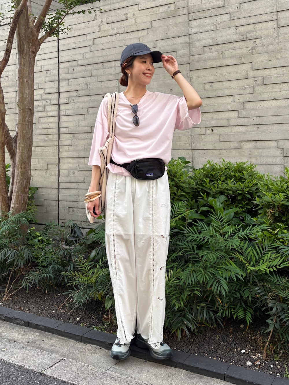 ピンク系のTシャツ/カットソー、グリーン系のスニーカー、ブラック系のボディバッグ/ウエストポーチを着用したレディースの春コーディネートの2枚目の写真