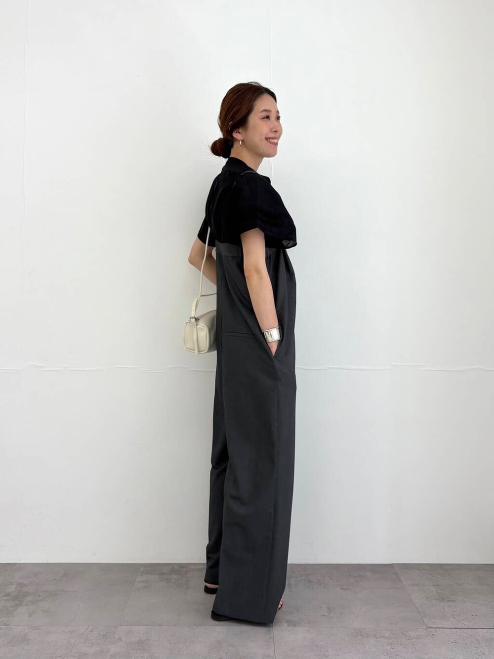 グレー系のサロペット/オーバーオール、ホワイト系のショルダーバッグ、ブラック系のサンダルを着用したレディースの夏コーディネートの2枚目の写真