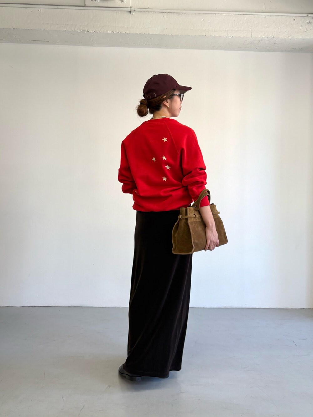 レッド系のスウェット、ブラウン系のトートバッグ、ブラック系のローファーを着用したレディースの秋コーディネートの5枚目の写真