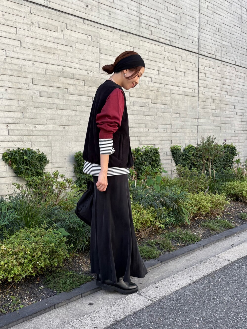 レッド系のスウェット、ブラック系のスカート、ブラック系のショルダーバッグを着用したレディースの秋コーディネートの2枚目の写真