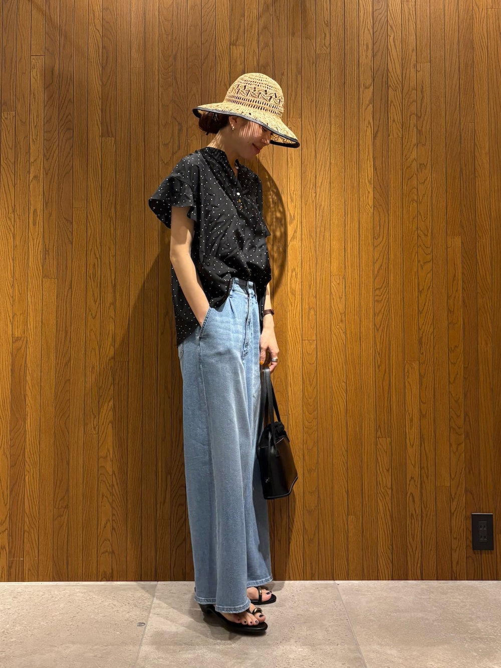 ブラック系のシャツ/ブラウス、ブルー系のデニムパンツ、ブラック系のサンダルを着用したレディースの春コーディネートの2枚目の写真