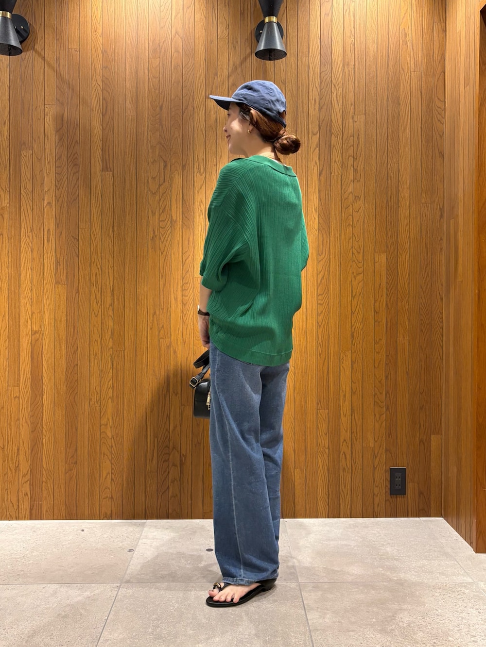 ホワイト系のTシャツ/カットソー、ブルー系のデニムパンツ、ブラック系のハンドバッグを着用したレディースの夏コーディネートの3枚目の写真