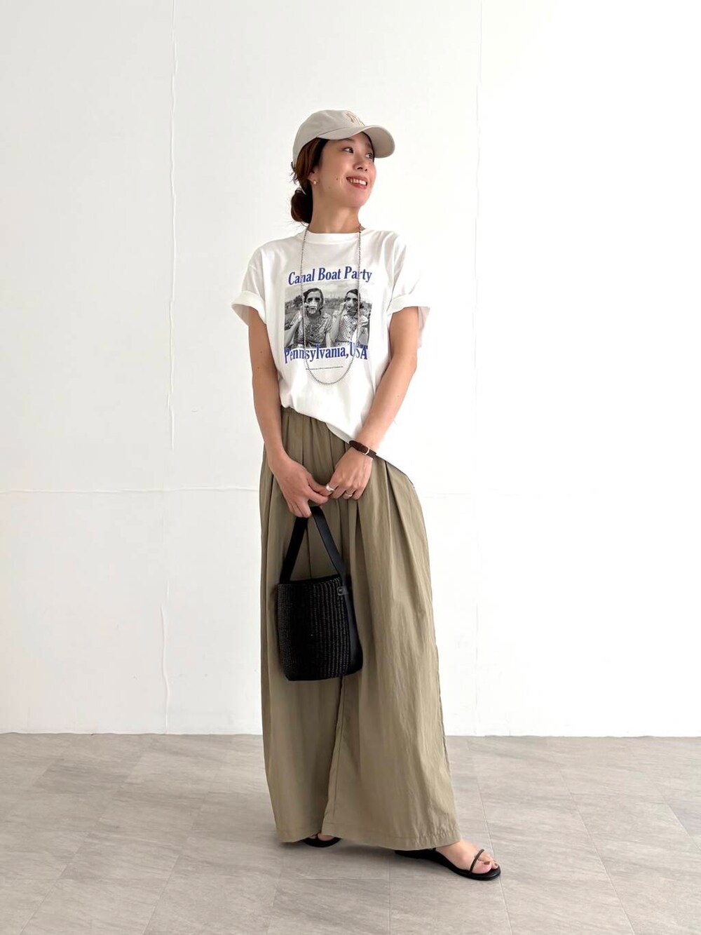 ベージュ系のその他パンツ、ブラック系のかごバッグ、ブラック系のサンダルを着用したレディースの夏コーディネートの5枚目の写真