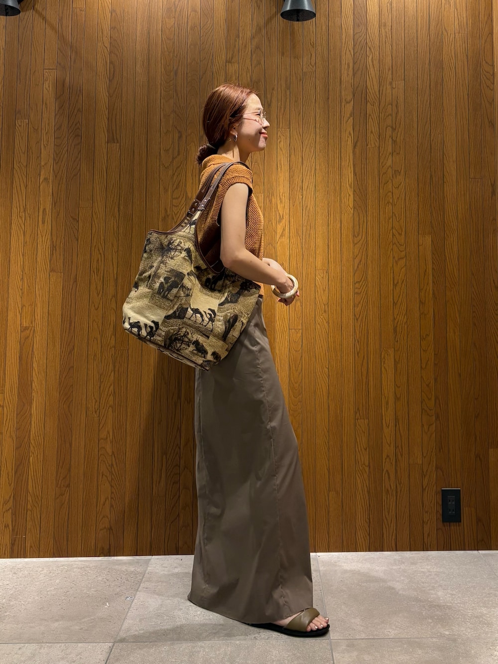 ブラウン系のニット/セーター、グレー系のスカート、ベージュ系のトートバッグを着用したレディースの夏コーディネートの5枚目の写真