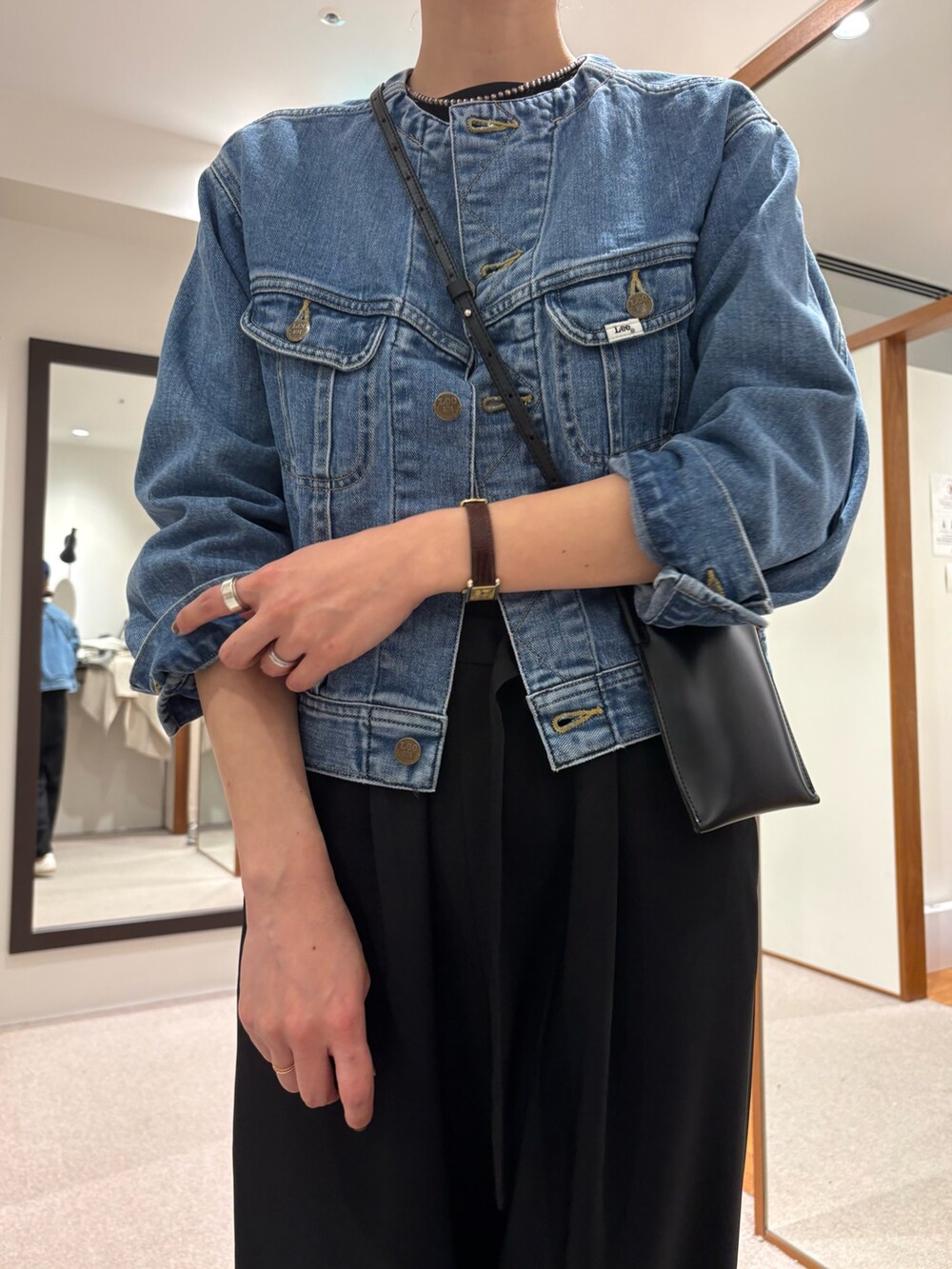 ブルー系のデニムジャケット、ブラック系のその他パンツ、ホワイト系のスニーカーを着用したレディースの冬コーディネートの6枚目の写真
