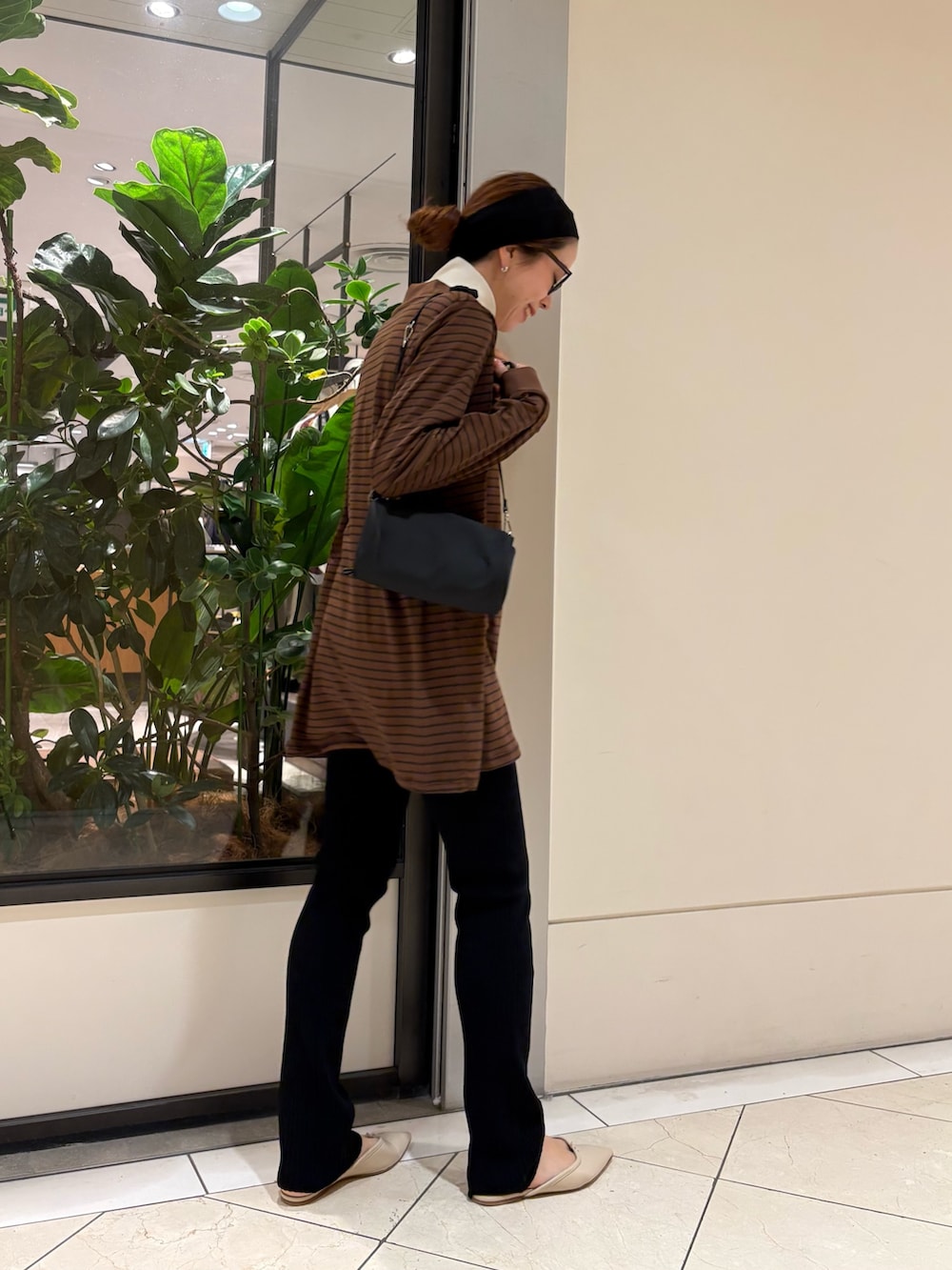 ブラウン系のポロシャツ、ブラック系のその他パンツ、ブラック系のハンドバッグを着用したレディースの秋コーディネートの5枚目の写真
