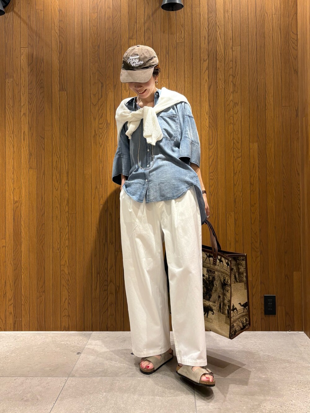 ブルー系のシャツ/ブラウス、ホワイト系のその他パンツ、ベージュ系のハンドバッグを着用したレディースの春コーディネートの5枚目の写真