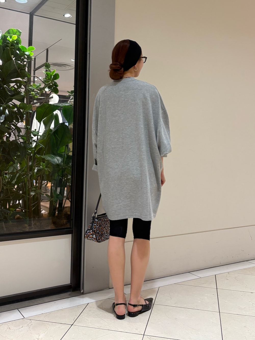 パープル系のハンドバッグ、ブラック系のパンプス、グレー系のワンピースを着用したレディースの春コーディネートの3枚目の写真
