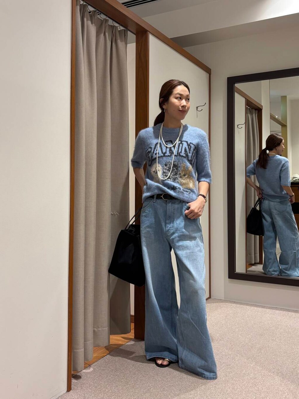 ブルー系のデニムパンツ、ブラック系のサンダルを着用したレディースの夏コーディネートの5枚目の写真