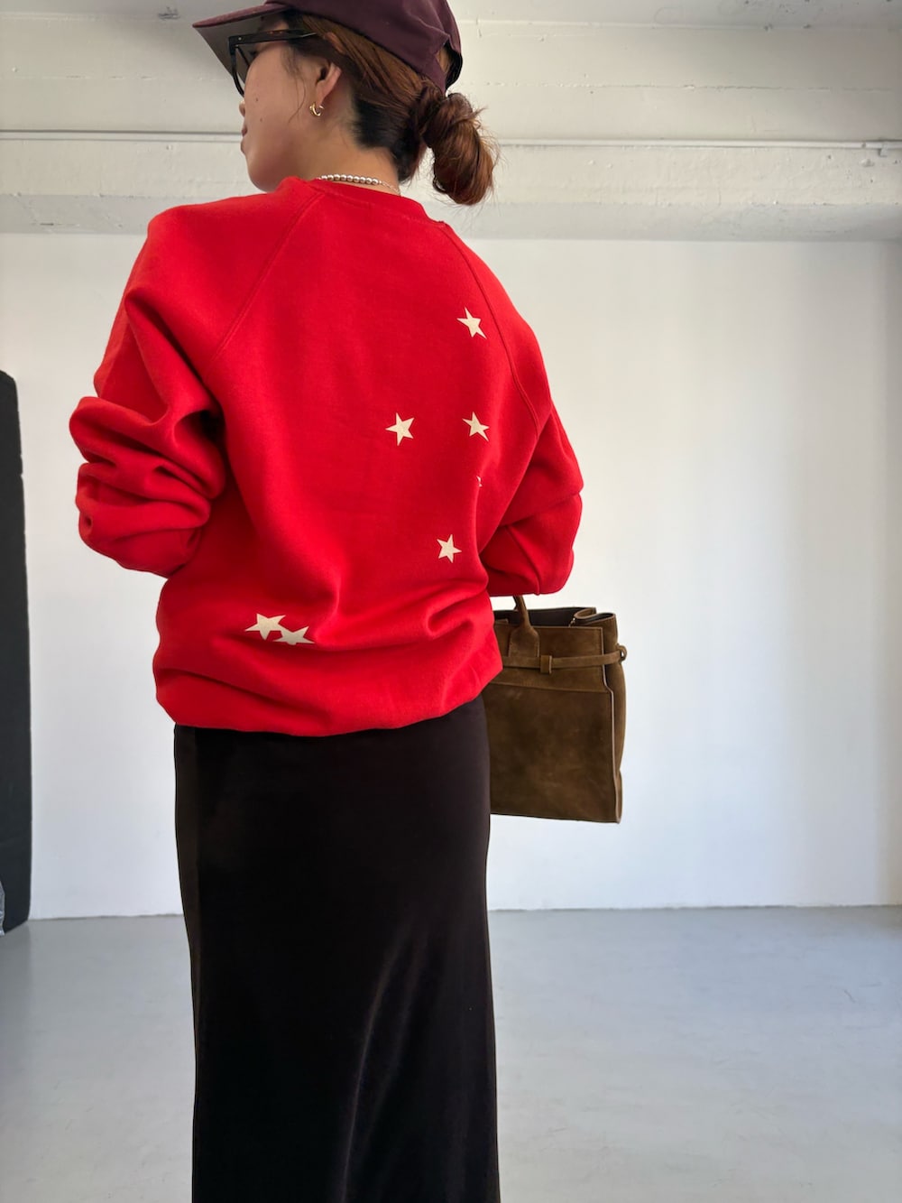 レッド系のスウェット、ブラウン系のトートバッグ、ブラック系のローファーを着用したレディースの秋コーディネートの8枚目の写真