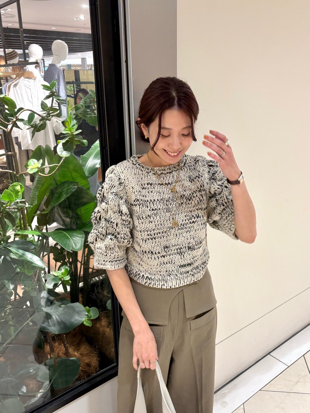 ホワイト系のニット/セーター、ブラウン系のその他パンツ、ホワイト系のハンドバッグを着用したレディースの秋コーディネートの5枚目の写真