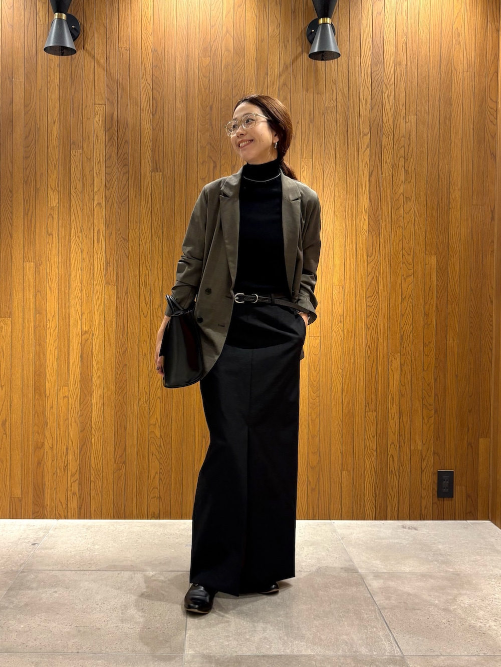 ブラック系のスカート、ブラック系のニット/セーター、ブラック系のハンドバッグを着用したレディースの秋コーディネートの7枚目の写真