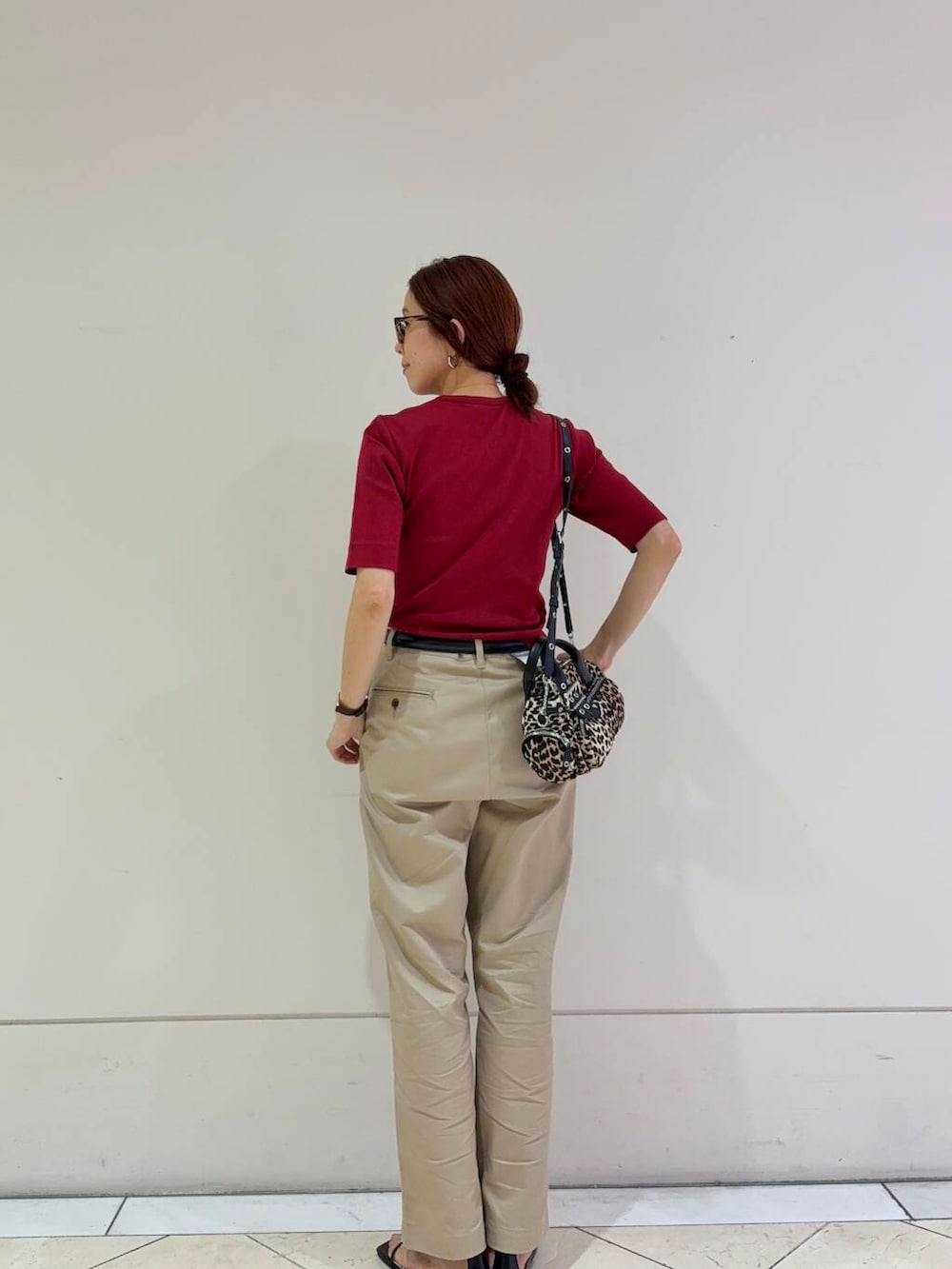 ベージュ系のチノパンツ、ブラック系のサンダル、レッド系のTシャツ/カットソーを着用したレディースの夏コーディネートの3枚目の写真