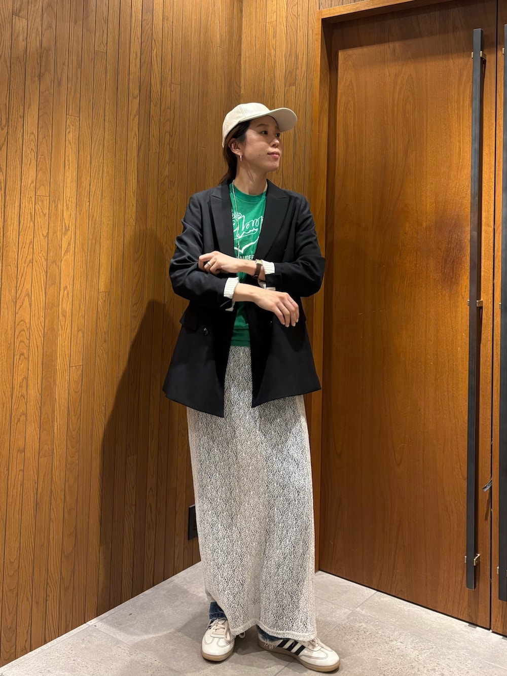 ホワイト系のスカート、ブラック系のその他アウター、ホワイト系のスニーカーを着用したレディースの冬コーディネートの3枚目の写真