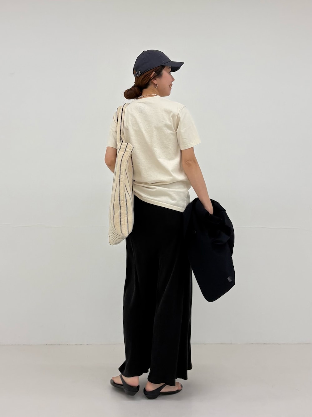 ブルー系のその他アウター、ブラック系のスカート、ベージュ系のTシャツ/カットソーを着用したレディースの春コーディネートの7枚目の写真