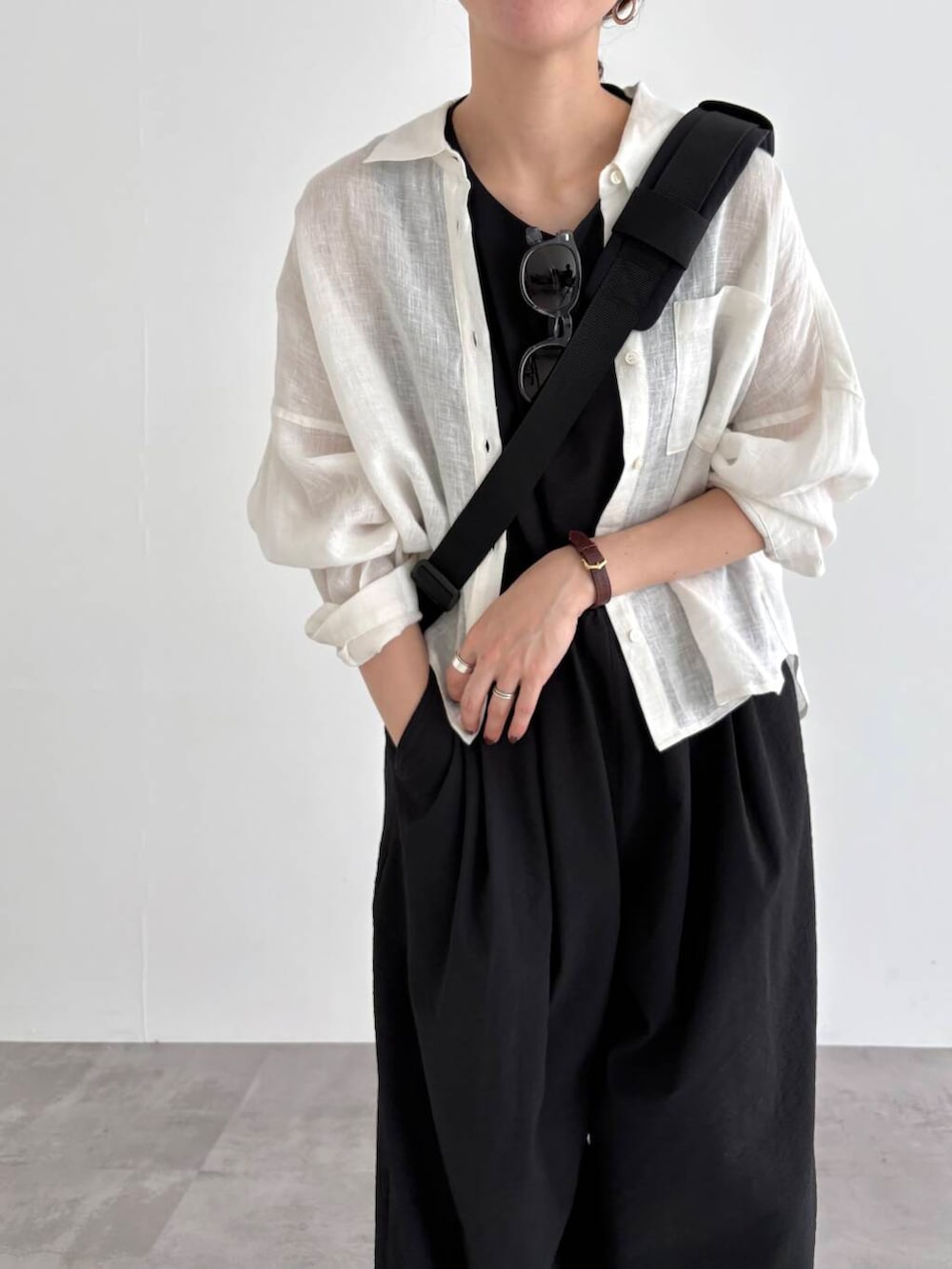 ホワイト系のシャツ/ブラウス、ブラック系のバックパック/リュック、ブラック系のサロペット/オーバーオールを着用したレディースの春コーディネートの3枚目の写真