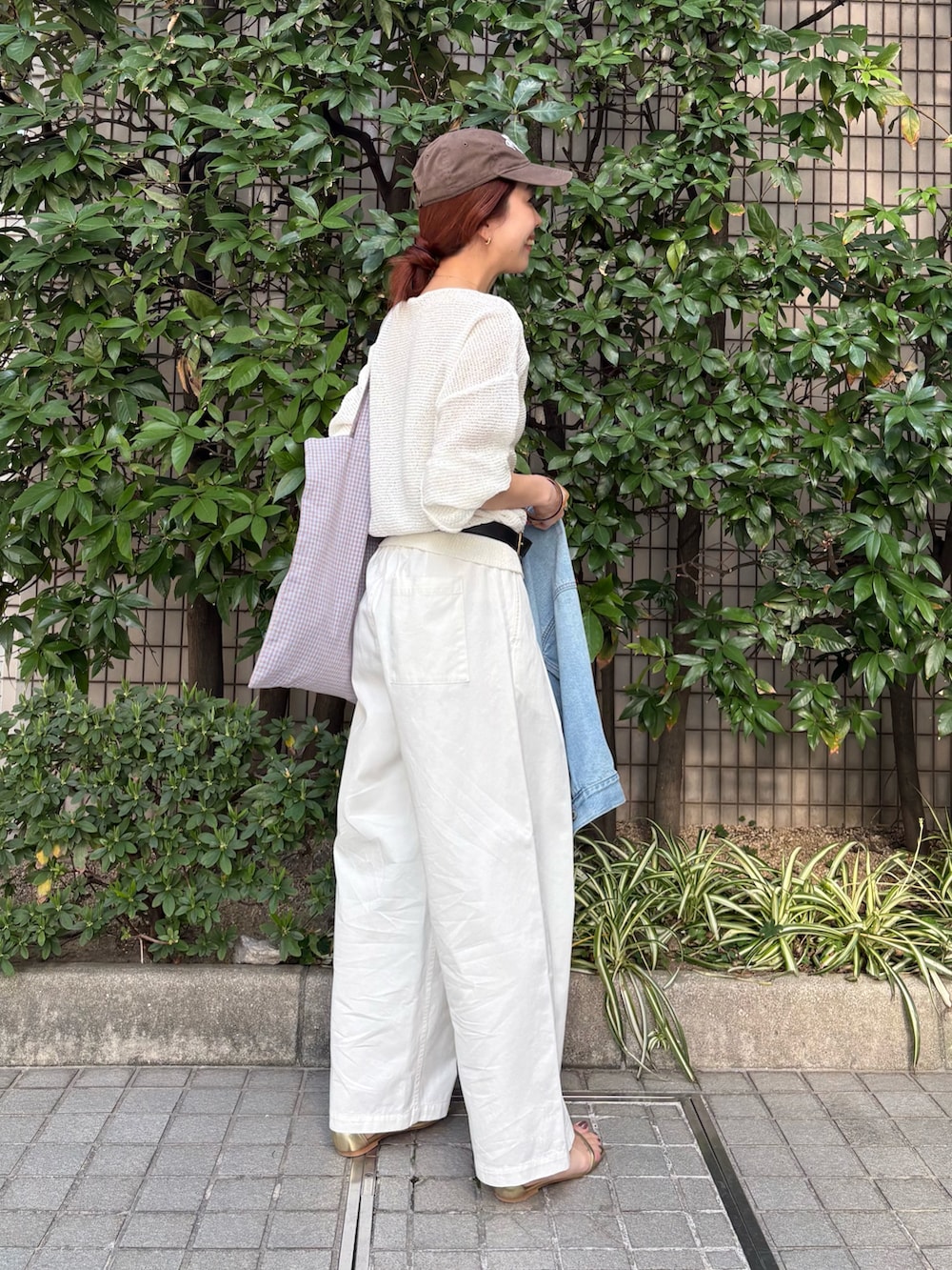 ホワイト系のニット/セーター、ブルー系のデニムジャケット、その他のトートバッグを着用したレディースの春コーディネートの2枚目の写真