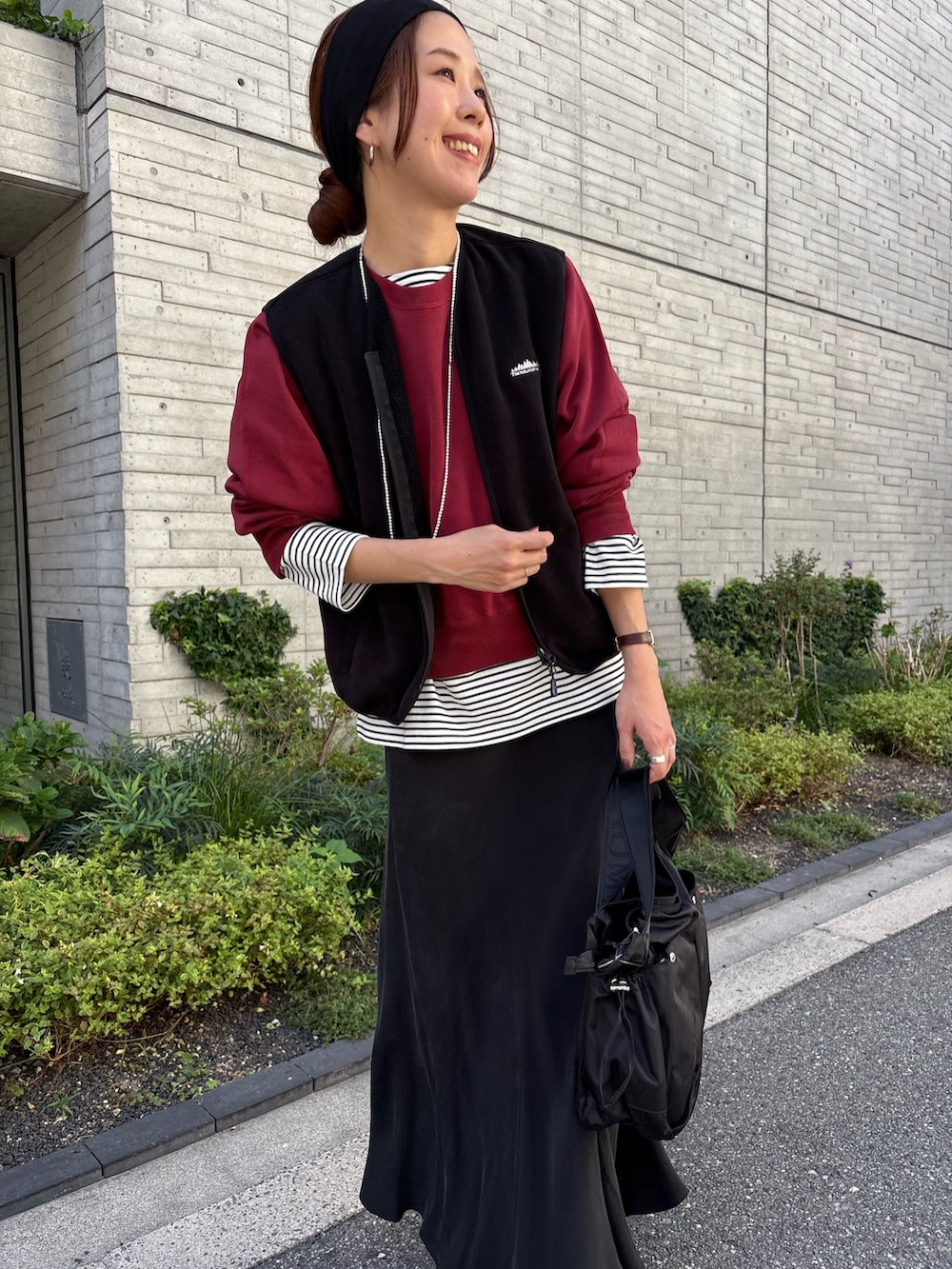 レッド系のスウェット、ブラック系のスカート、ブラック系のショルダーバッグを着用したレディースの秋コーディネートの6枚目の写真