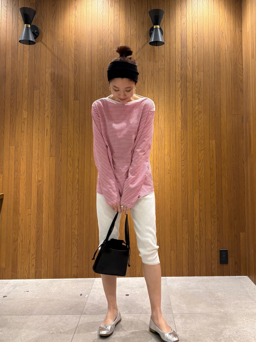 ベージュ系のその他アウター、レッド系のTシャツ/カットソー、ブラック系のハンドバッグを着用したレディースの春コーディネートの6枚目の写真