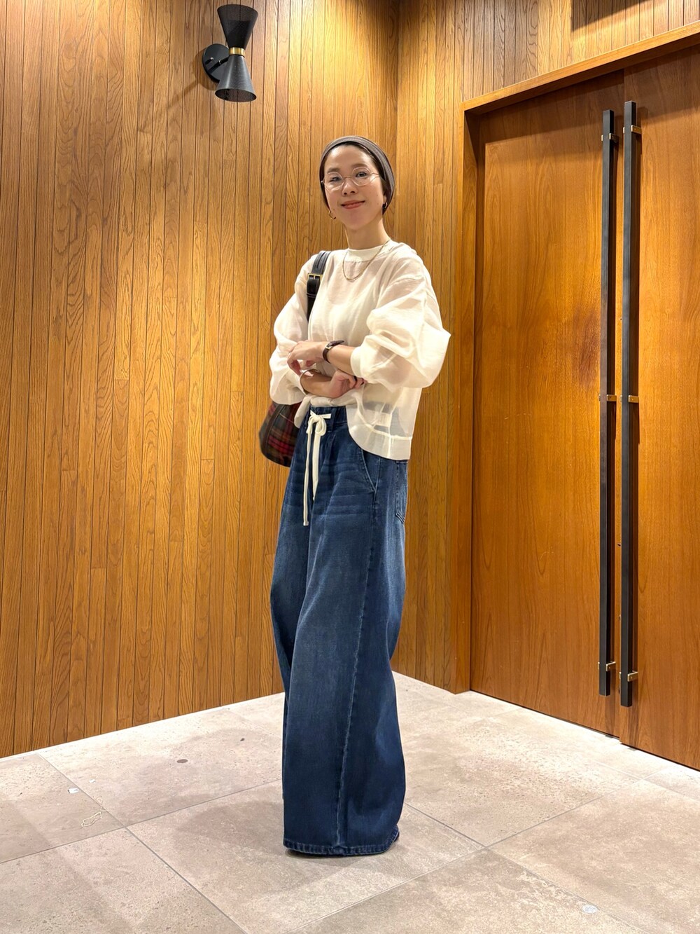 ブルー系のデニムパンツ、その他のショルダーバッグ、ホワイト系のTシャツ/カットソーを着用したレディースの夏コーディネートの2枚目の写真