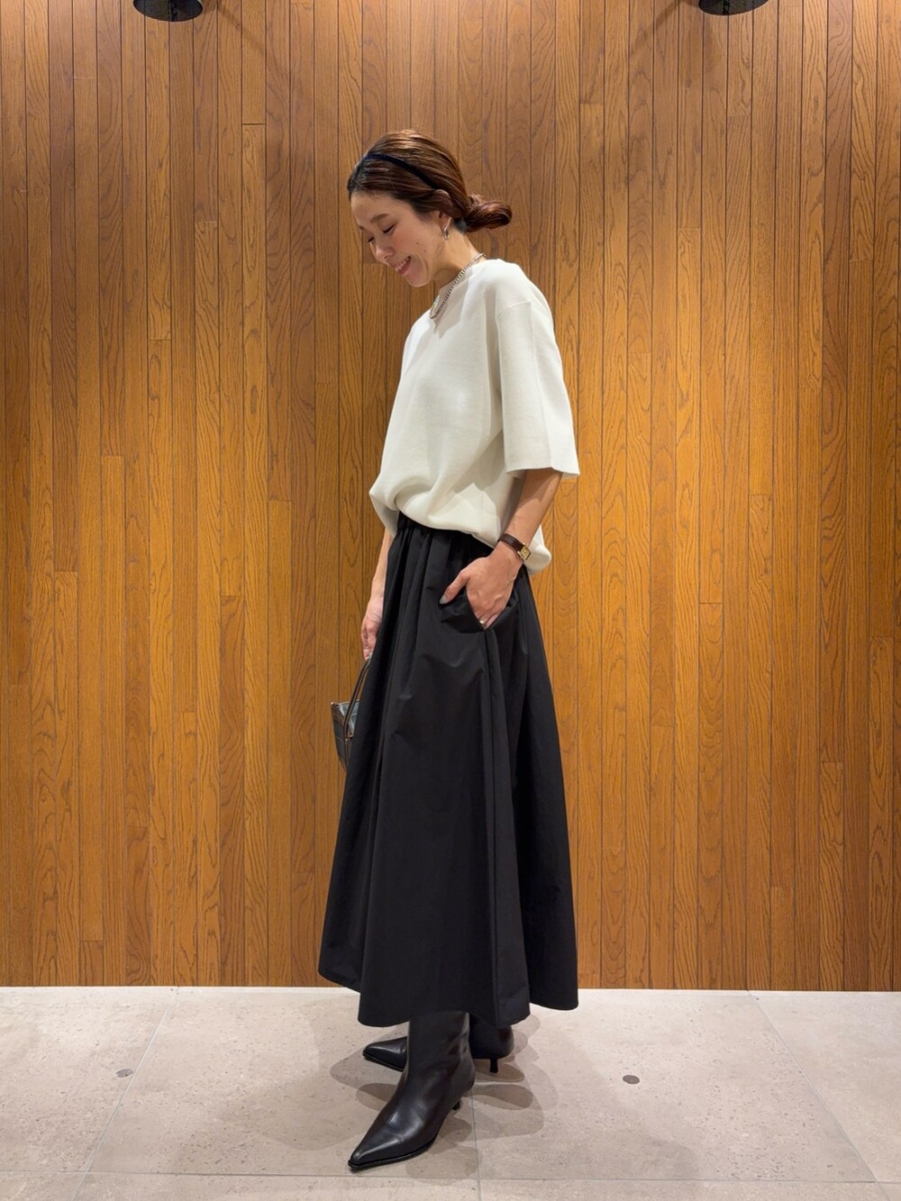 ホワイト系のニット/セーター、ブラック系のブーツ、ブラック系のスカートを着用したレディースの秋コーディネートの3枚目の写真