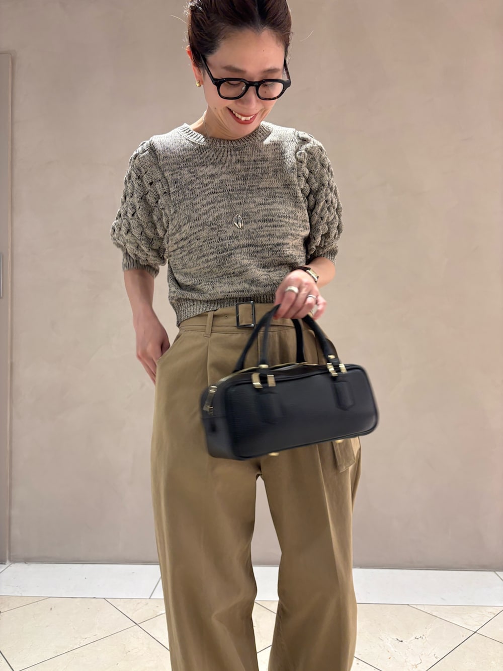 ベージュ系のその他パンツ、ブラック系のハンドバッグ、ホワイト系のニット/セーターを着用したレディースの春コーディネートの5枚目の写真
