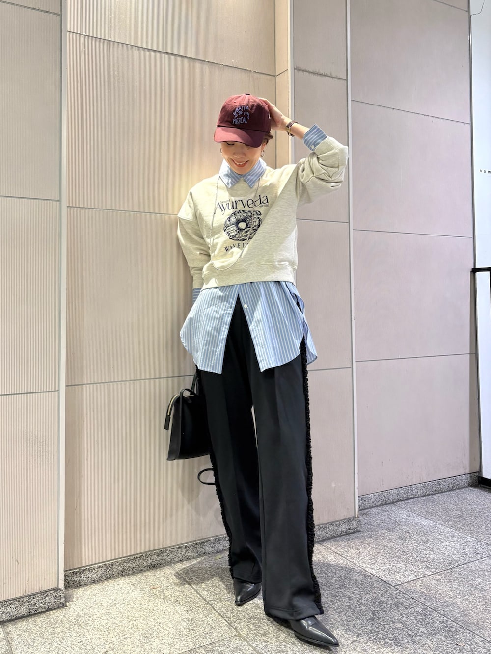 ベージュ系のスウェット、ブラック系のブーツ、ブラック系のショルダーバッグを着用したレディースの冬コーディネートの4枚目の写真