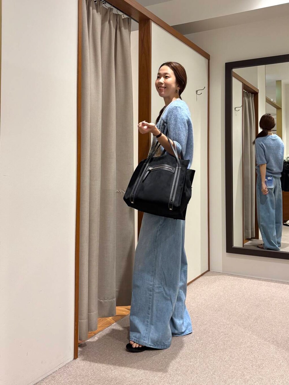 ブルー系のデニムパンツ、ブラック系のサンダルを着用したレディースの夏コーディネートの2枚目の写真