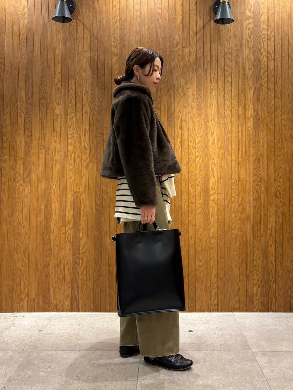 イエロー系のニット/セーター、ベージュ系のその他パンツ、ブラック系のハンドバッグを着用したレディースの冬コーディネートの7枚目の写真