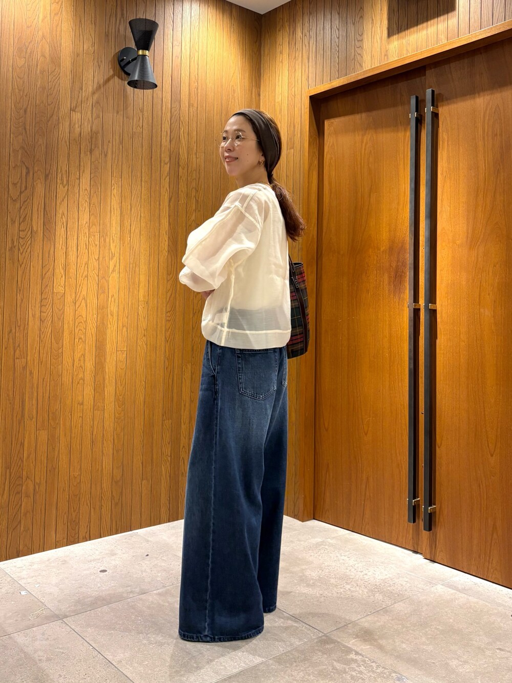 ブルー系のデニムパンツ、その他のショルダーバッグ、ホワイト系のTシャツ/カットソーを着用したレディースの夏コーディネートの3枚目の写真