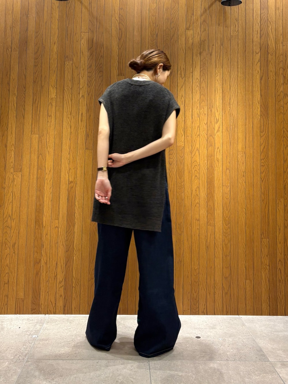 ブラック系のデニムパンツ、ブラック系のニット/セーター、ホワイト系のポーチを着用したレディースの夏コーディネートの3枚目の写真