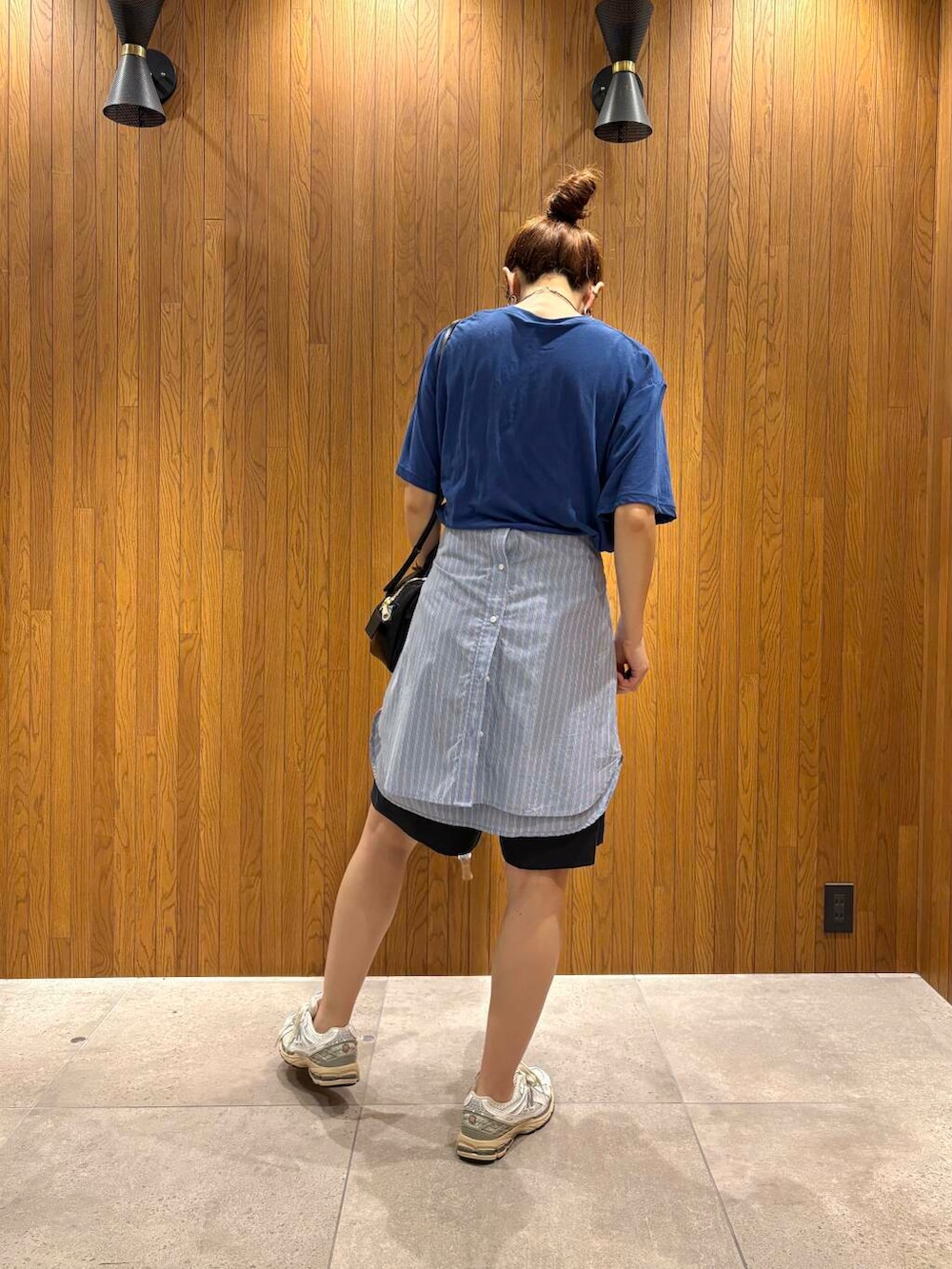 ブルー系のシャツ/ブラウス、シルバー系のスニーカー、ブラック系のショルダーバッグを着用したレディースの夏コーディネートの3枚目の写真