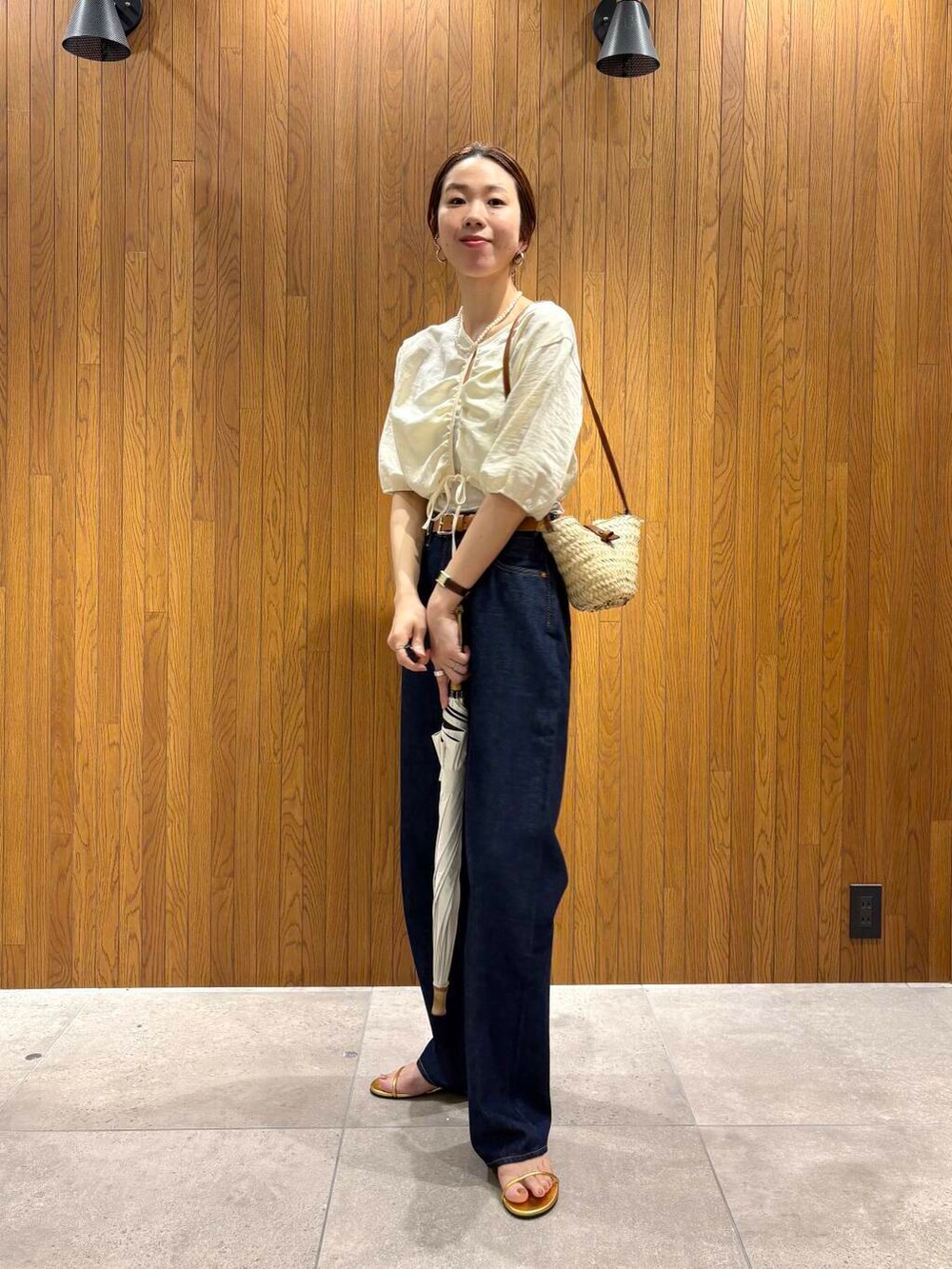 ベージュ系のシャツ/ブラウス、ゴールド系のサンダル、ホワイト系の長傘を着用したレディースの夏コーディネートの2枚目の写真