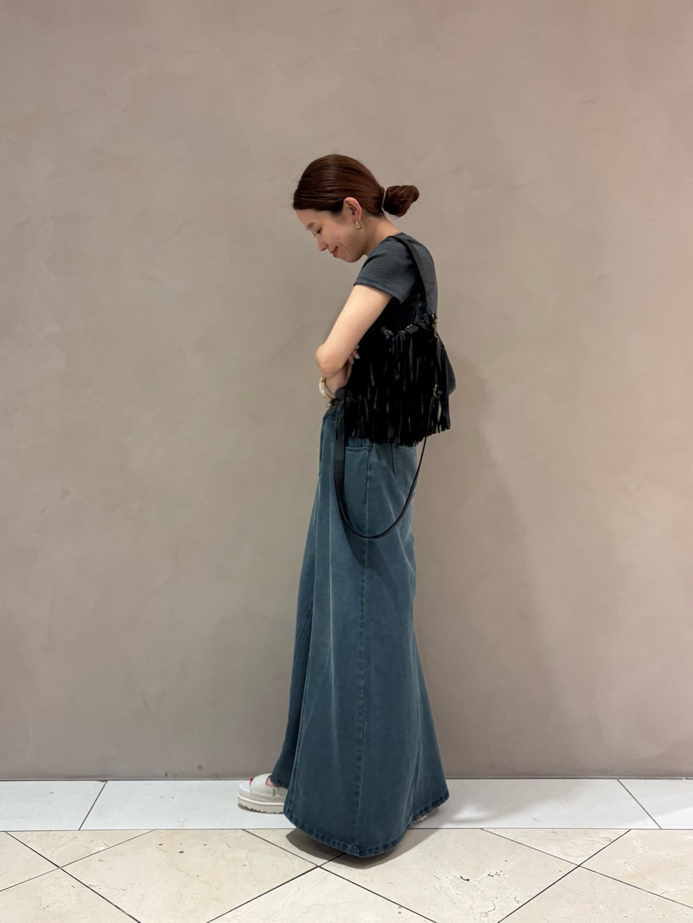 グレー系のTシャツ/カットソー、ブラック系のハンドバッグ、ブラック系のベルトを着用したレディースの春コーディネートの2枚目の写真