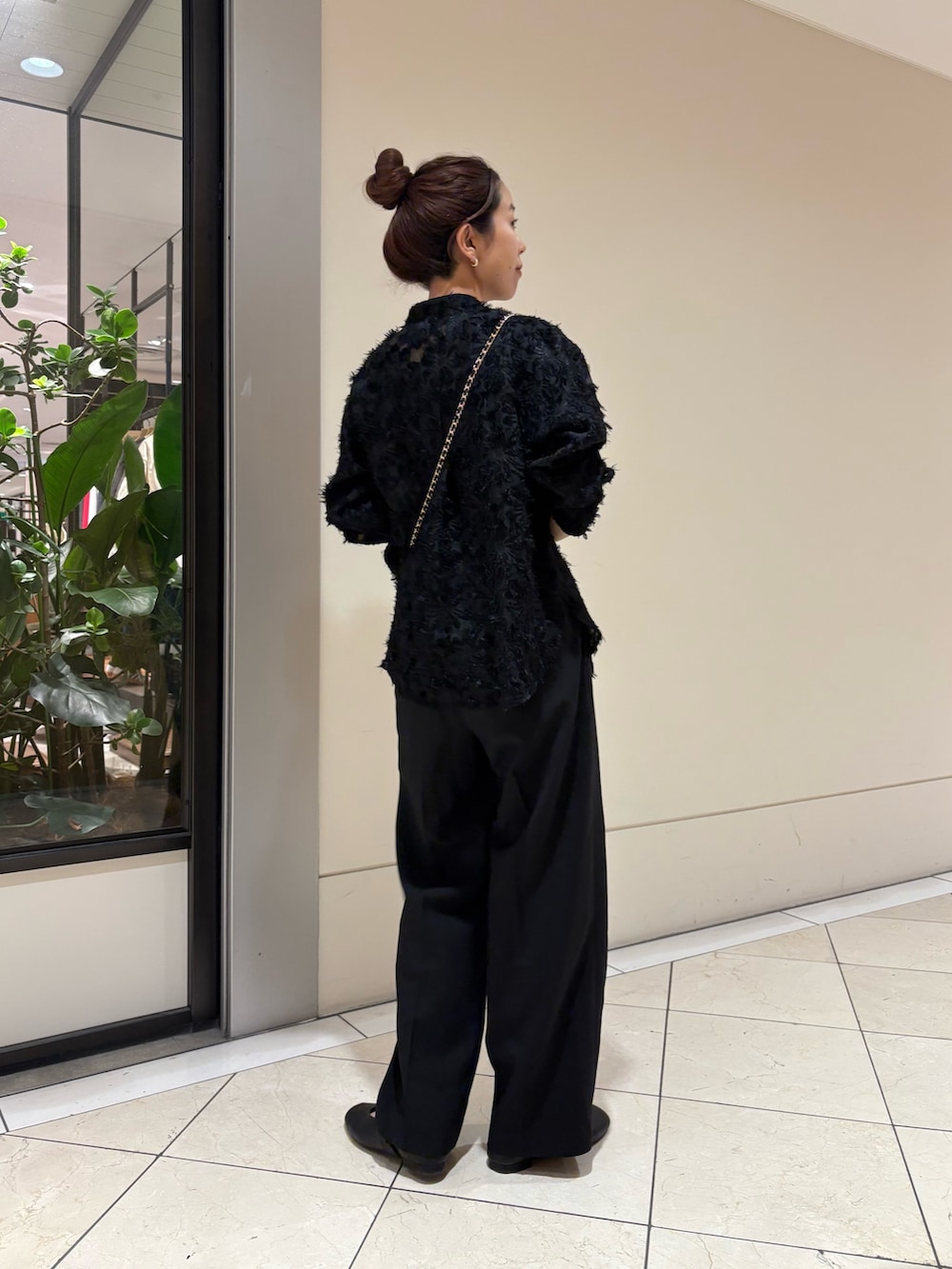 ブラック系のシャツ/ブラウス、ブラック系のスラックス、ブラウン系のショルダーバッグを着用したレディースの冬コーディネートの2枚目の写真