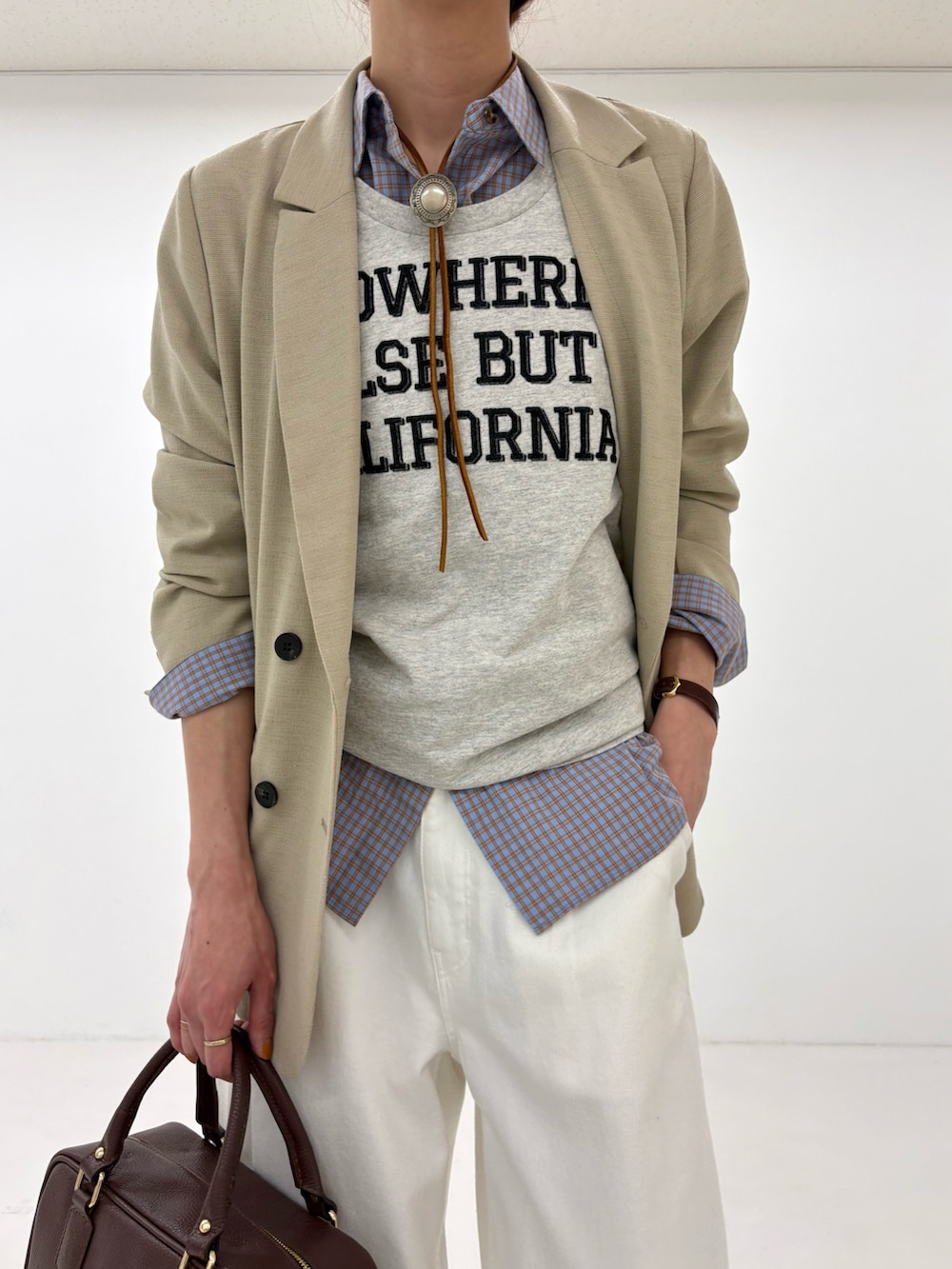 ベージュ系のその他アウター、ブルー系のシャツ/ブラウス、ホワイト系のデニムパンツを着用したレディースの春コーディネートの6枚目の写真