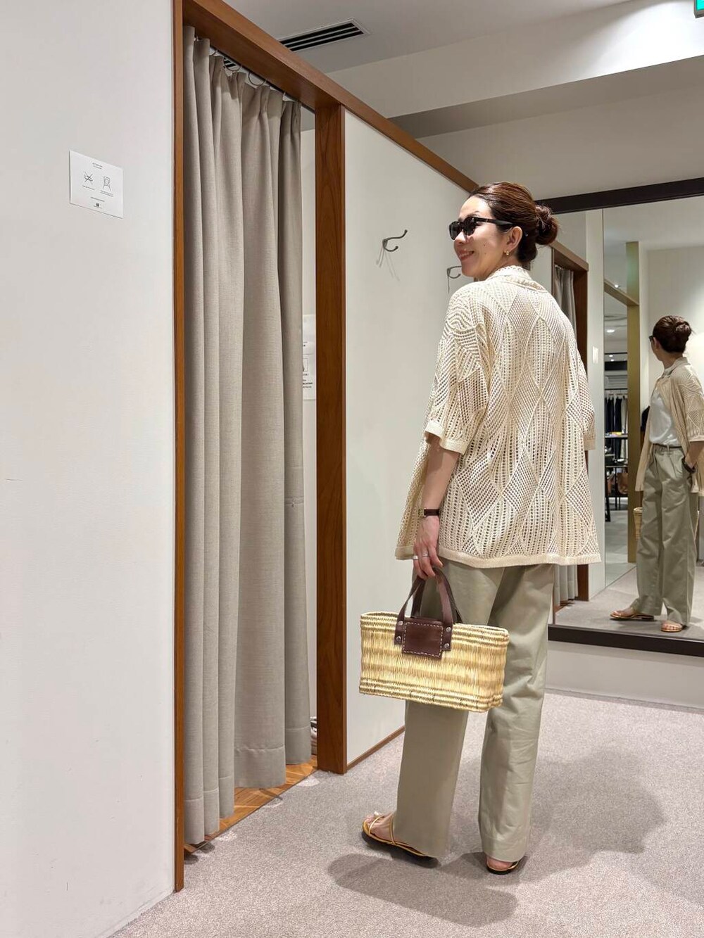 ブラウン系のかごバッグ、ホワイト系のその他アウター、ゴールド系のサンダルを着用したレディースの春コーディネートの2枚目の写真